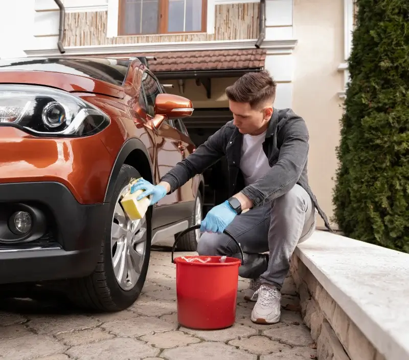 Lavage auto à domicile Les Portes du Coglais : professionnel intervenant sur un véhicule